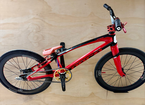 Red and black bicycle on a wooden floor