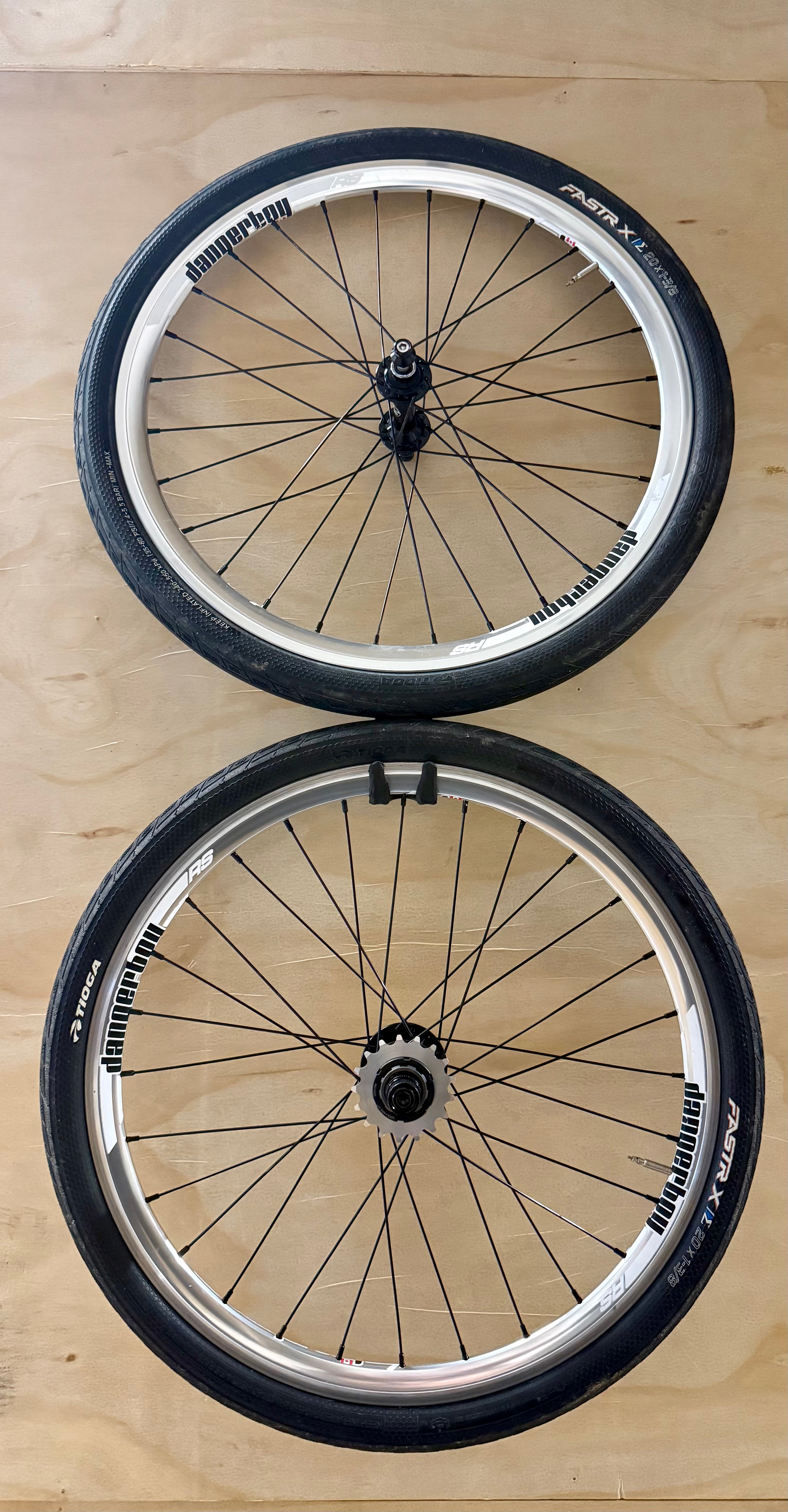 Two bicycle wheels on a wooden surface