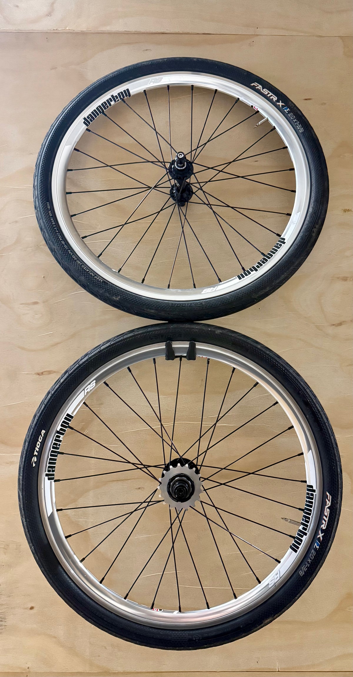 Two bicycle wheels on a wooden surface