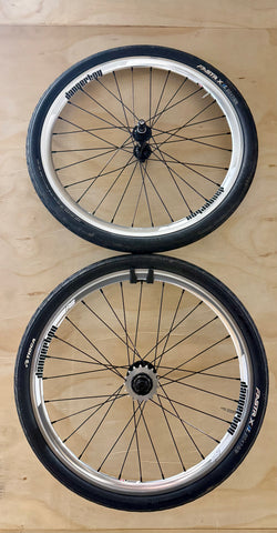 Two bicycle wheels on a wooden surface