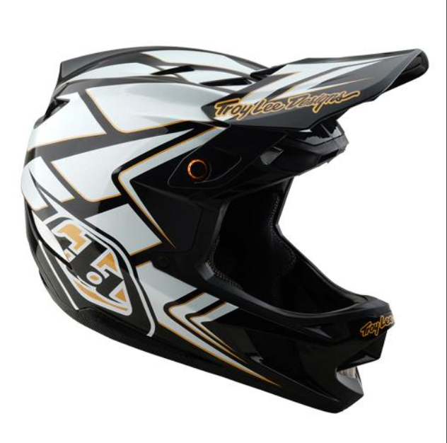 Motocross helmet with black, white, and gold design on a white background