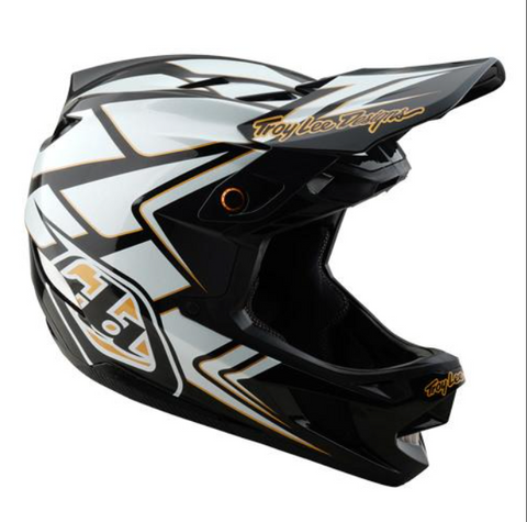Motocross helmet with black, white, and gold design on a white background