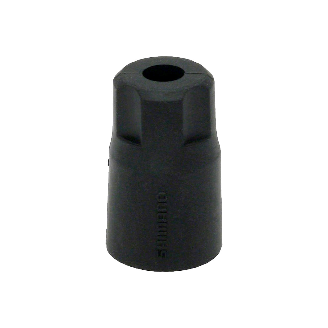 Black cylindrical object with a central hole on a white background