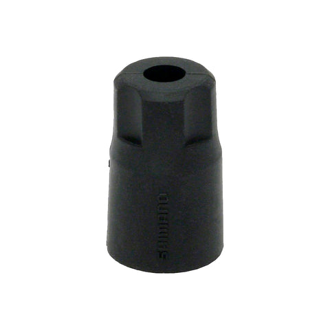 Black cylindrical object with a central hole on a white background